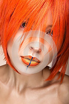 Beautiful girl in an orange wig cosplay style with bright creative lips. Art beauty image.