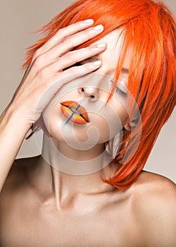 Beautiful girl in an orange wig cosplay style with bright creative lips. Art beauty image.