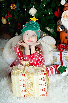 Beautiful girl in pajamas with gift box is waiting Christmas and New year