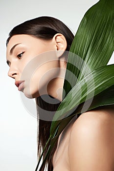 beautiful girl with palm leaves. Beautiful young woman with Make-up
