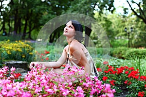 Beautiful girl in park with colorful flowers