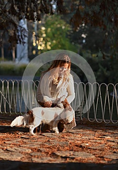 Beautiful girl in the park enjoying with her dog Cavalier King Charles Spaniel