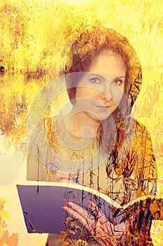 Beautiful girl with a pensive look holds a book, tree branches, a double exposure