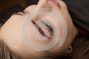 Beautiful girl permanent eyebrow makeup correction. The second PMU procedure after a month of permanent eyebrow makeup