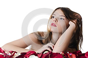 The beautiful girl with petals of roses isolated