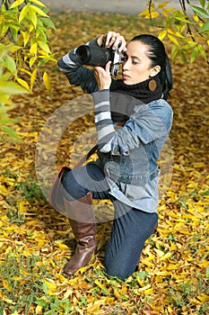 Beautiful girl photographer knee on nature