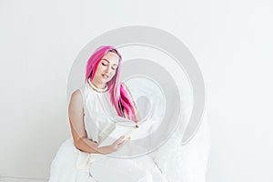 Beautiful girl with pink hair reads the book education