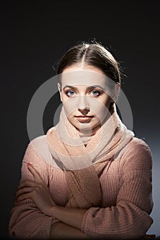 Beautiful girl in pink knitted sweater. emotional portrait on a dark background.