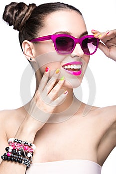 Beautiful girl in pink sunglasses with bright makeup and colorful nails. Beauty face.