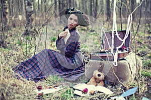 Beautiful girl in a plaid dress in the woods