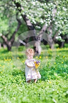 Beautiful girl playing with flowers in a garden