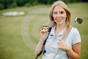 Beautiful girl playing golf on a golf course