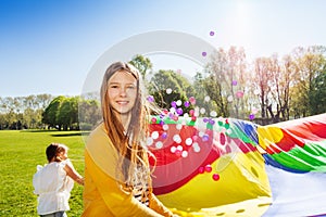 Beautiful girl playing parachute game with friends