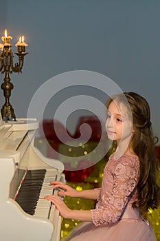 Beautiful Girl Playing Piano and Looking at Burning Candles