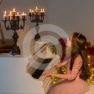 Beautiful Girl Playing Piano and Looking at Burning Candles