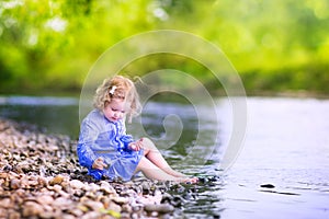 Beautiful girl playing at river shore