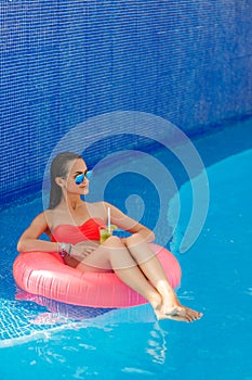 Beautiful girl in the pool on inflatable lifebuoy