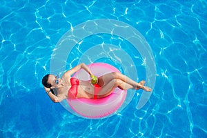 Beautiful girl in the pool on inflatable lifebuoy