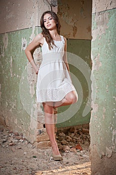 Beautiful girl posing fashion near an old wall