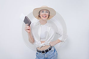 Beautiful girl posing on a white background in a beautiful yellow hat with a passport and boarding pass. Tourism concept