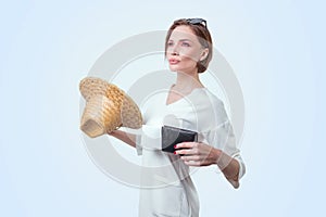 Beautiful girl posing on a white background in a beautiful yellow hat with a passport and boarding pass. Tourism concept