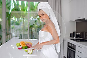 Beautiful girl preparing a healthy breakfast of fruit in the morning