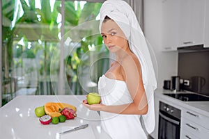 Beautiful girl preparing a healthy breakfast of fruit in the morning