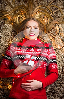 Beautiful girl with present box and festive lights