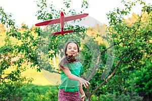 Beautiful girl pretend to be pilot. Kid having fun at countryside. Summer vacation and travel concept