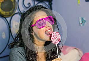 Beautiful girl with professional make-up with a colorful lollipop