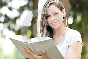 Beautiful girl reading a book outdoor