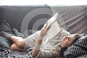 Girl reading book on sofa