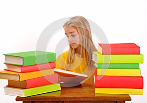 Beautiful girl reading a book surrounded by books