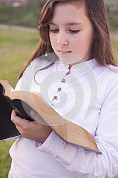 Beautiful girl reading holy bible