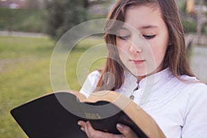 Beautiful girl reading holy bible