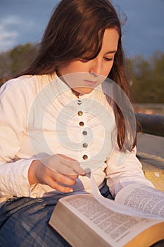 Beautiful girl reading holy bible