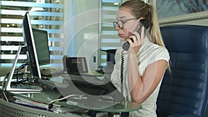 Beautiful girl at the reception desk answering the call in medical center