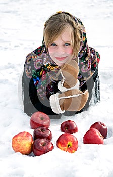 Beautiful girl with red apples on snow