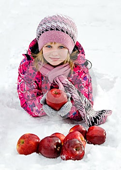 Beautiful girl with red apples on snow