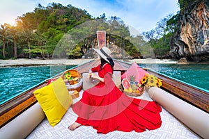 Beautiful girl in red dress on longtail boat at Koh Lao Lading island, Thailand photo