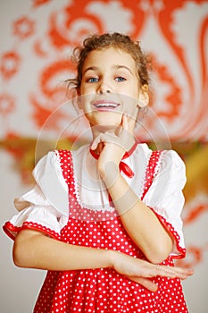 Beautiful girl in red folk costume poses and