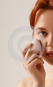 Beautiful girl with red hair and freckles . Skincare. Woman with beautiful face touching healthy facial skin