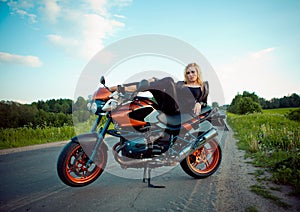 Beautiful girl with red a motorcycle in the sun