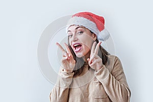 Beautiful girl in red Santa Claus hat  on white background. Winter portrait of young woman. Happy Christmas and