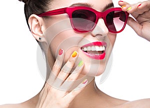 Beautiful girl in red sunglasses with bright makeup and colorful nails. Beauty face.