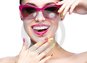 Beautiful girl in red sunglasses with bright makeup and colorful nails. Beauty face.