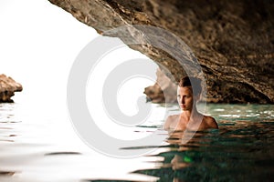 Beautiful girl with redhead tied hair in the water cave