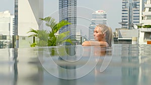 Beautiful girl is relaxing in an infinity pool