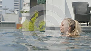 Beautiful girl is relaxing in an infinity pool