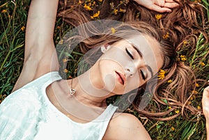 Beautiful girl is relaxing and lying on the grass